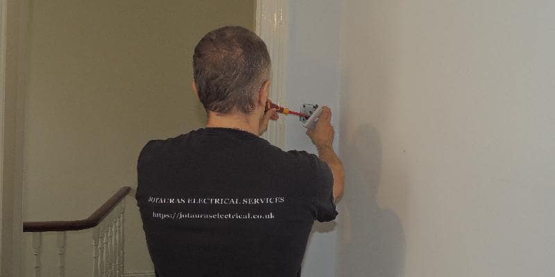 an electrician replaces the light switch